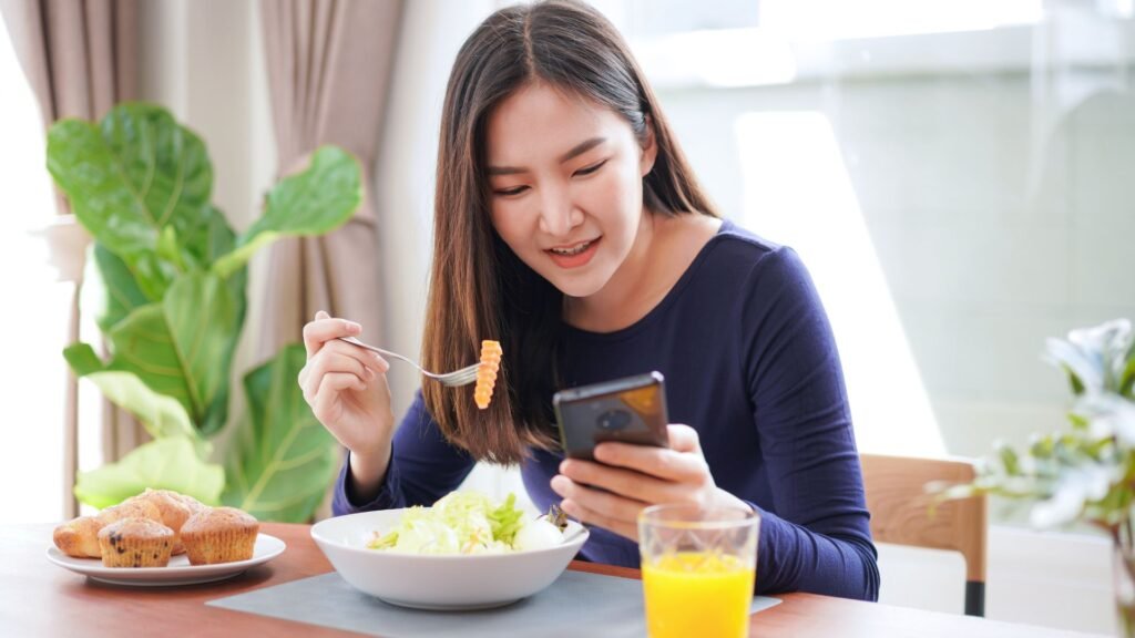 Girl eating while checking work updates on phone